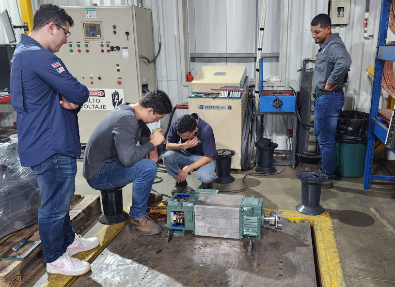 Practicantes realizando pruebas de motor bajo voltaje para evaluar rendimiento y seguridad | Interns performing low voltage motor tests to evaluate performance and safety